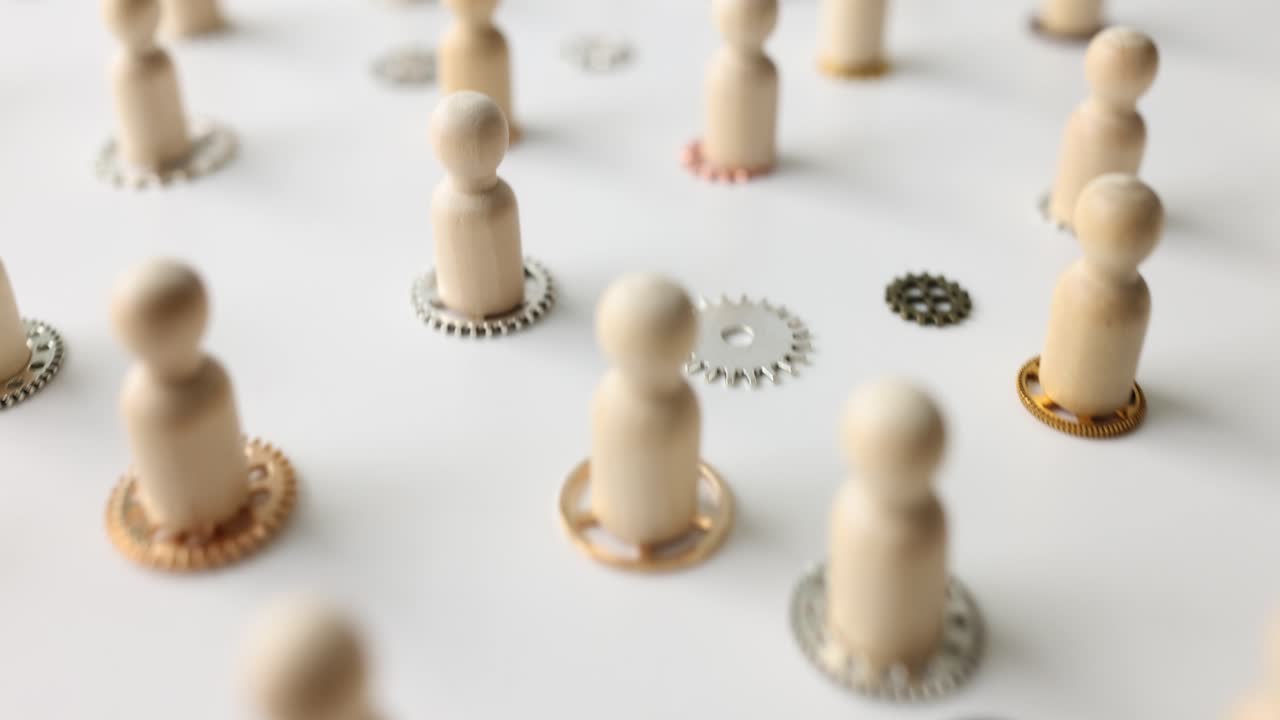 Figures of people put on gears on white surface in studio
