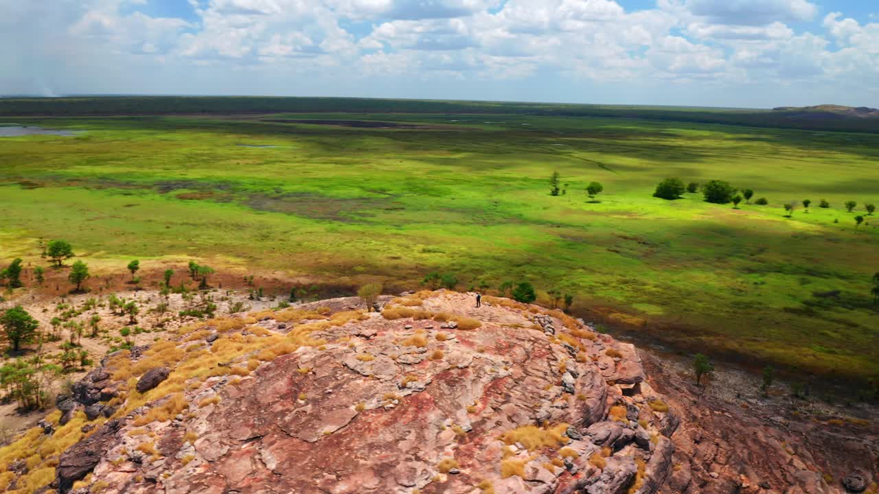 persona en la cima de las rocas en ubirr rodeada de humedales en el parque nacional kakadu, territorio del norte, australia