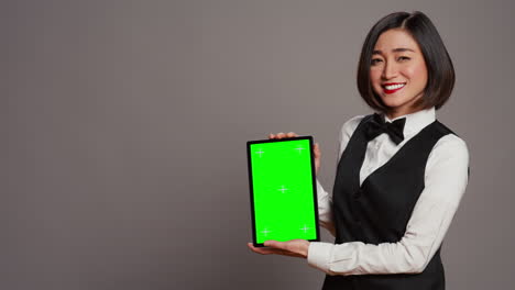 Woman-concierge-presenting-greenscreen-display-on-tablet