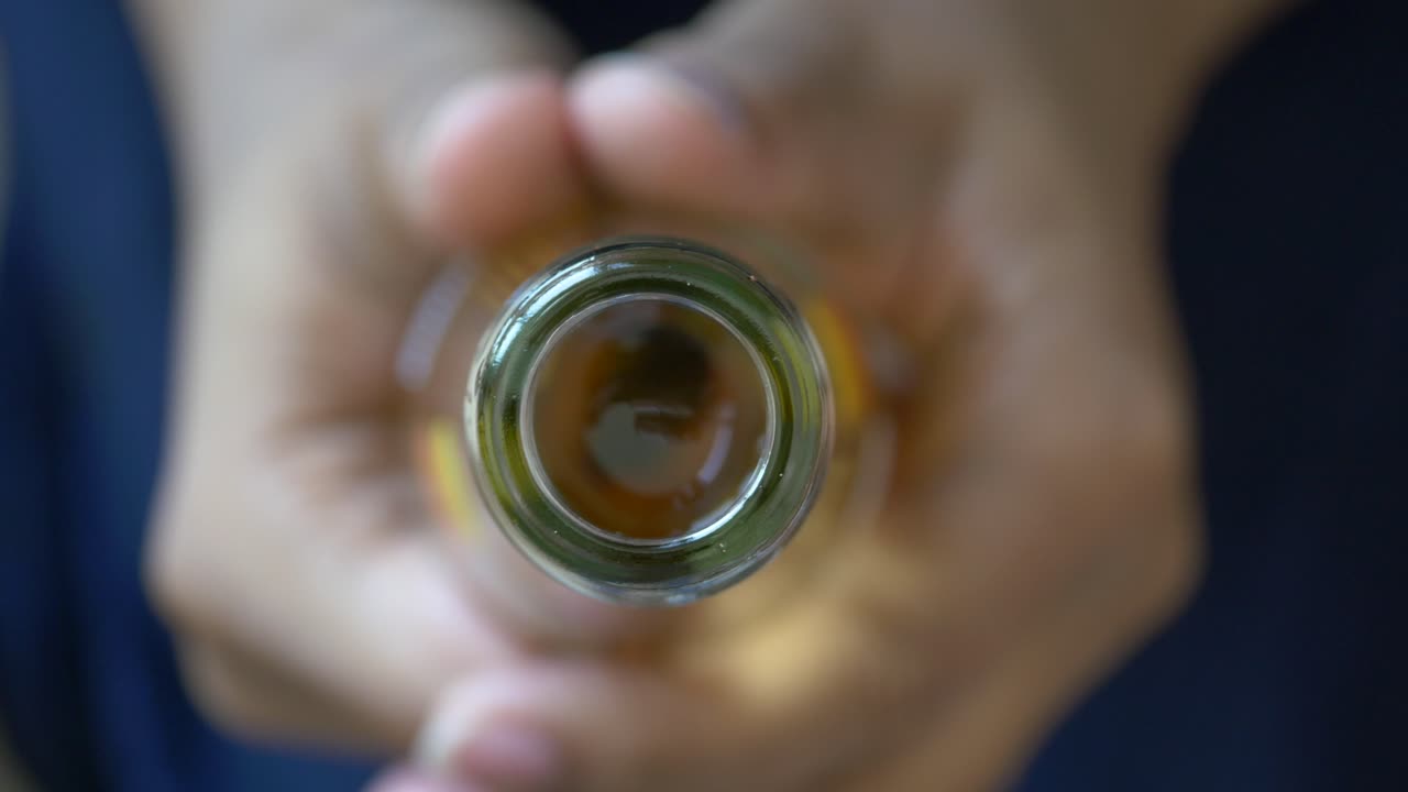 primer plano de un cuello de botella sostenido en las manos