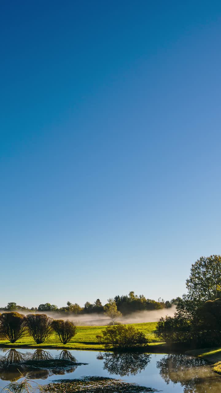 Early morning timelapse with fog clearing out over the landmark. Sunrise in verdant countryside. Nature in Latvia at sunrise. Vertical video.