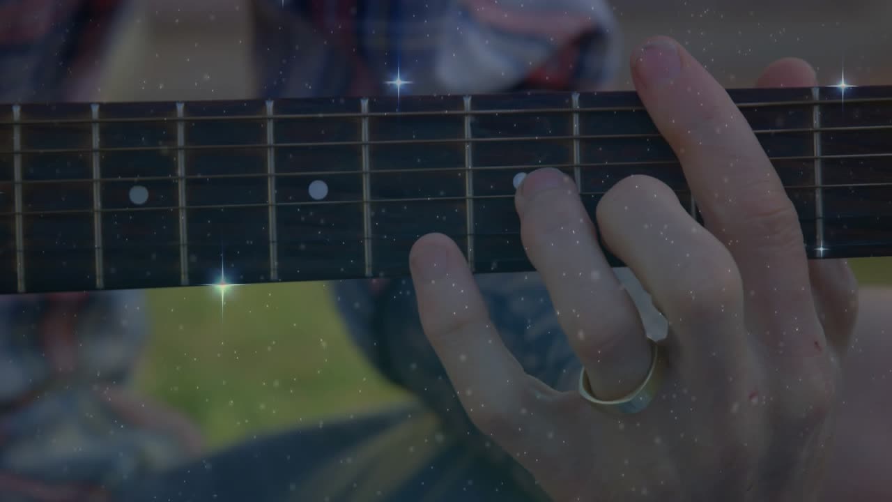 Man som oroar sig för gitarrhalsen med prickar, lyfter fingrarna och byter ackord för musiken, glitter överlagrat