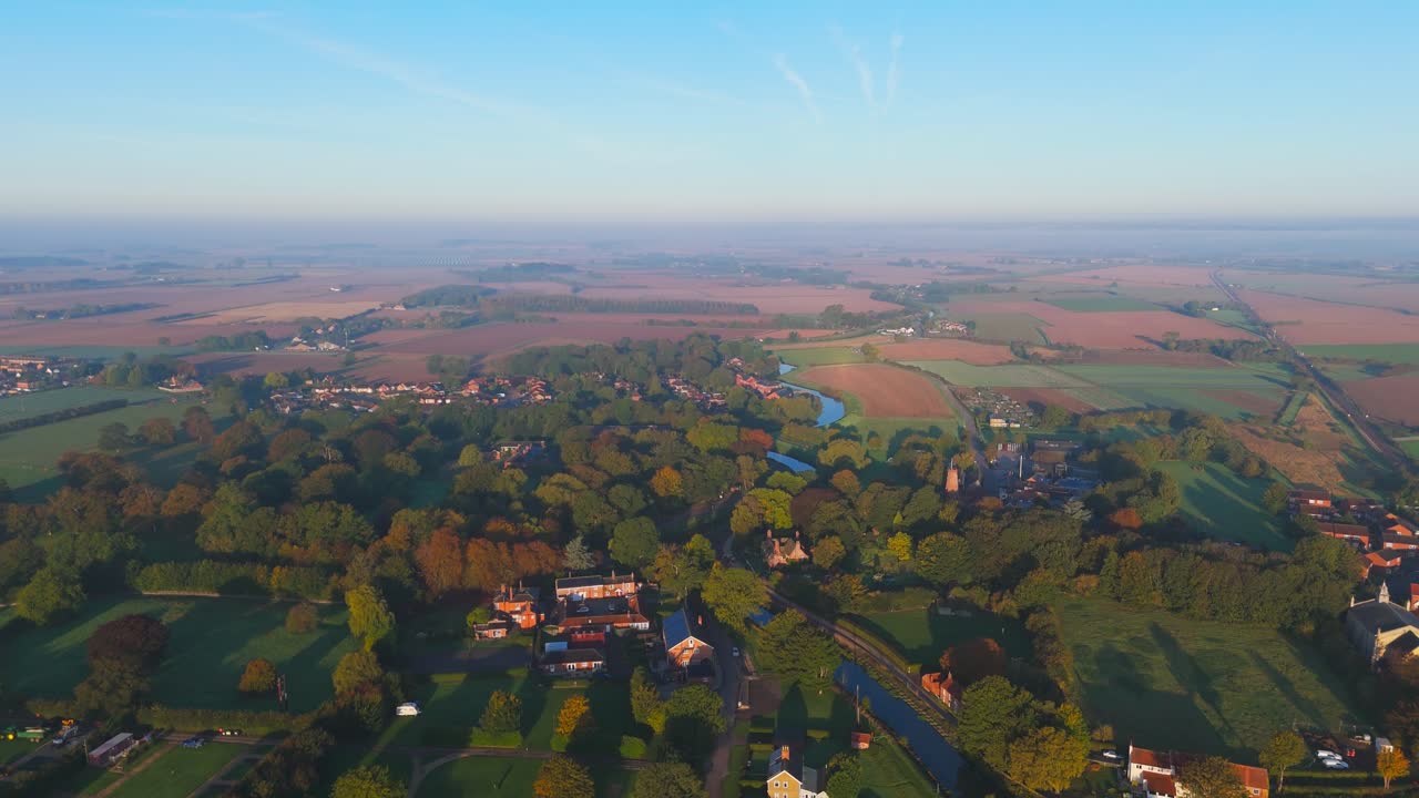 Misty autumn morning with farmlands and countryside views, wide vistas across open fields with crops set for overwintering. cold days in a rural village setting