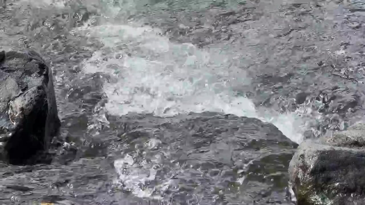 Acqua limpida che scorre su rocce di fiume