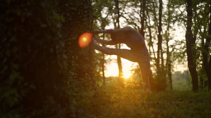 Woman Stretching Against a Tree in Forest