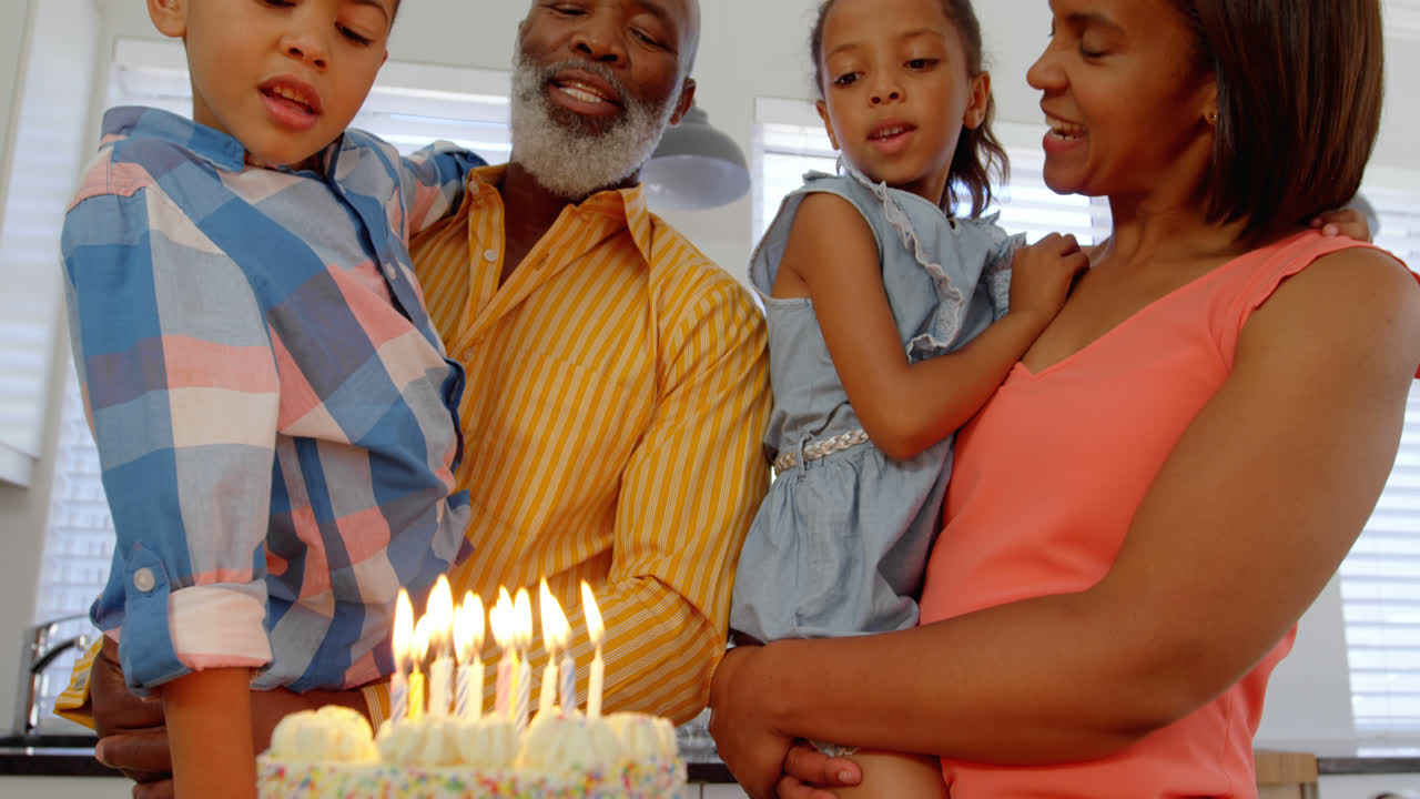 Front view of black family celebrating birthday in kitchen of comfortable home 4k