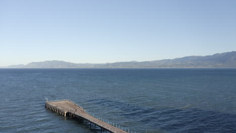 Aerial-flyover:-Fan-shaped-concrete-pier-on-Greek-Aegean-Sea-coast