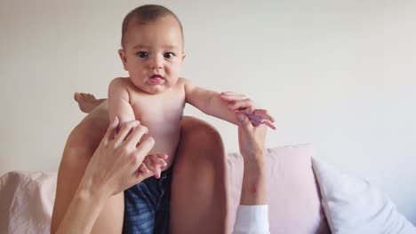 glückliche gesichtslose mutter, die mit dem baby im schlafzimmer spielt