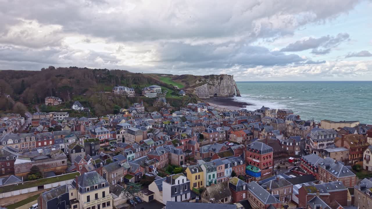 Łuk drona nad Étretat, a Falaise d’Aval wyłania się z morza, ptaków i chmur