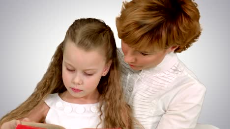 mother and daughter reading a book with enthusiasm on white background