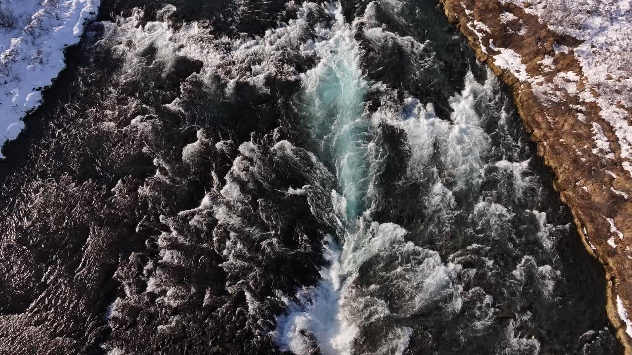 Aerial - Brúarfoss rapids cascade through snow in Haukadalur Iceland