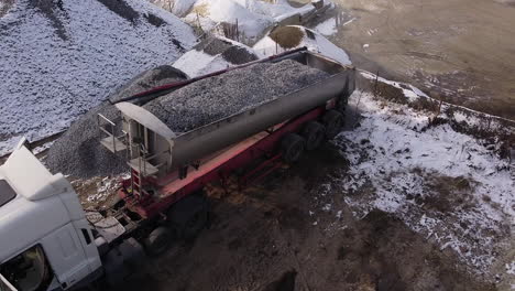 truck loading gravel in winter conditions