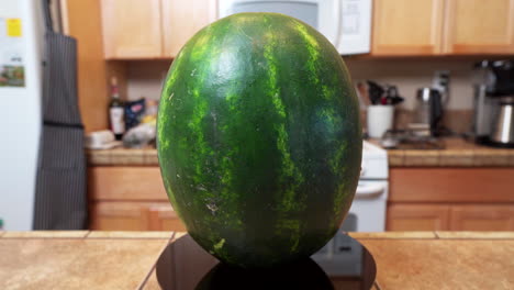 a fresh, ripe watermelon on a turning display in a home kitchen setting