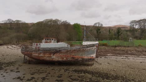 Low-aerial-establishing-shot-of-the-Corpach-Shipwreck-on-a-rocky-beach