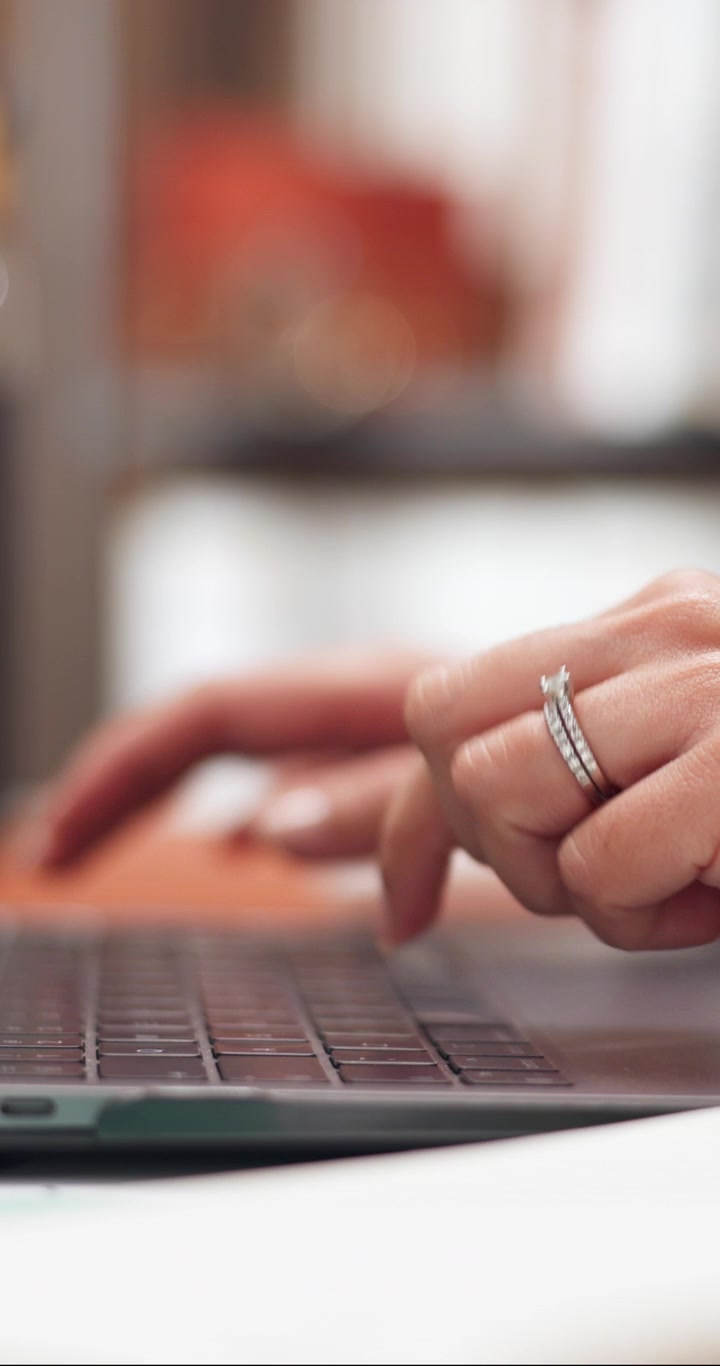 Woman Wearing Diamond Ring Typing on Laptop Keyboard