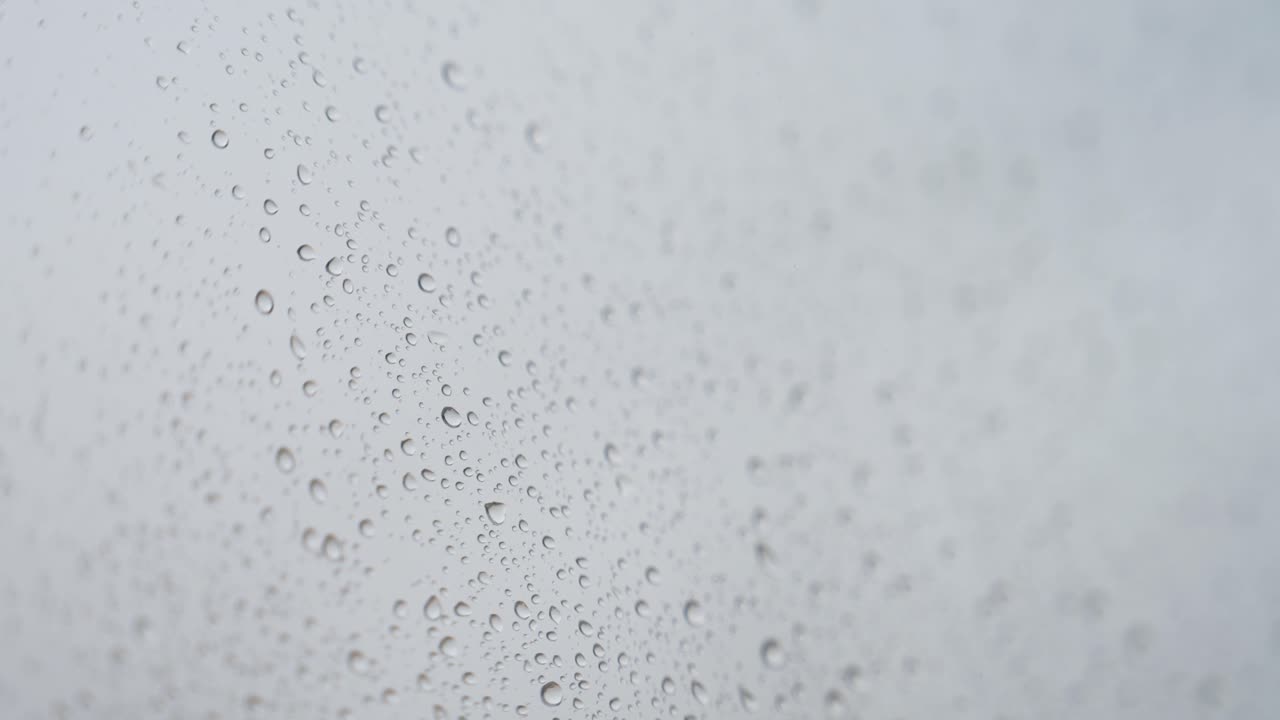 vidrio lluvioso cuando las gotas de lluvia golpean una ventana durante un clima sombrío y nublado