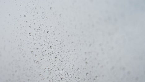 rainy glass as rain drops hits a window during a gloomy and overcast weather