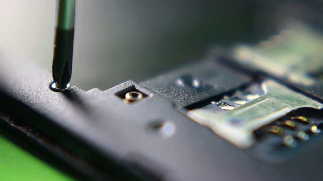 드라이버로 작은 나사를 스마트폰에 끼우다