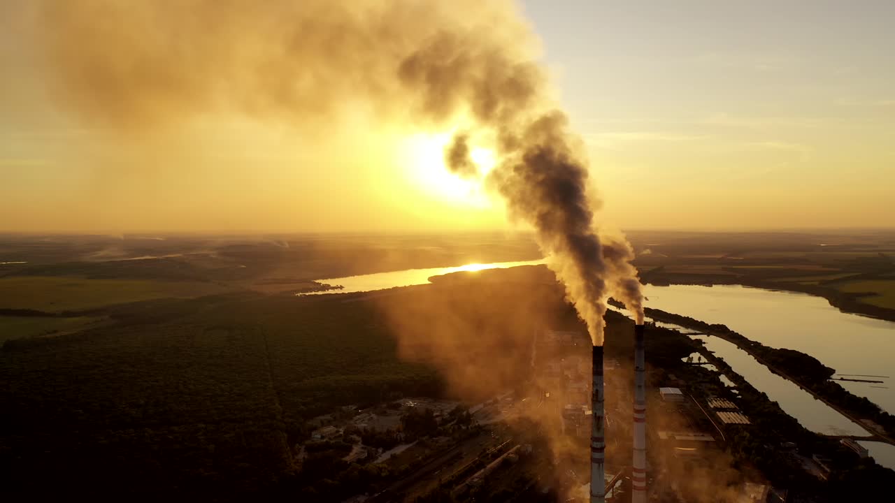 Smoking factory chimney. Plant emits smoke and smog from the pipes at sunset, pollutants enter the atmosphere