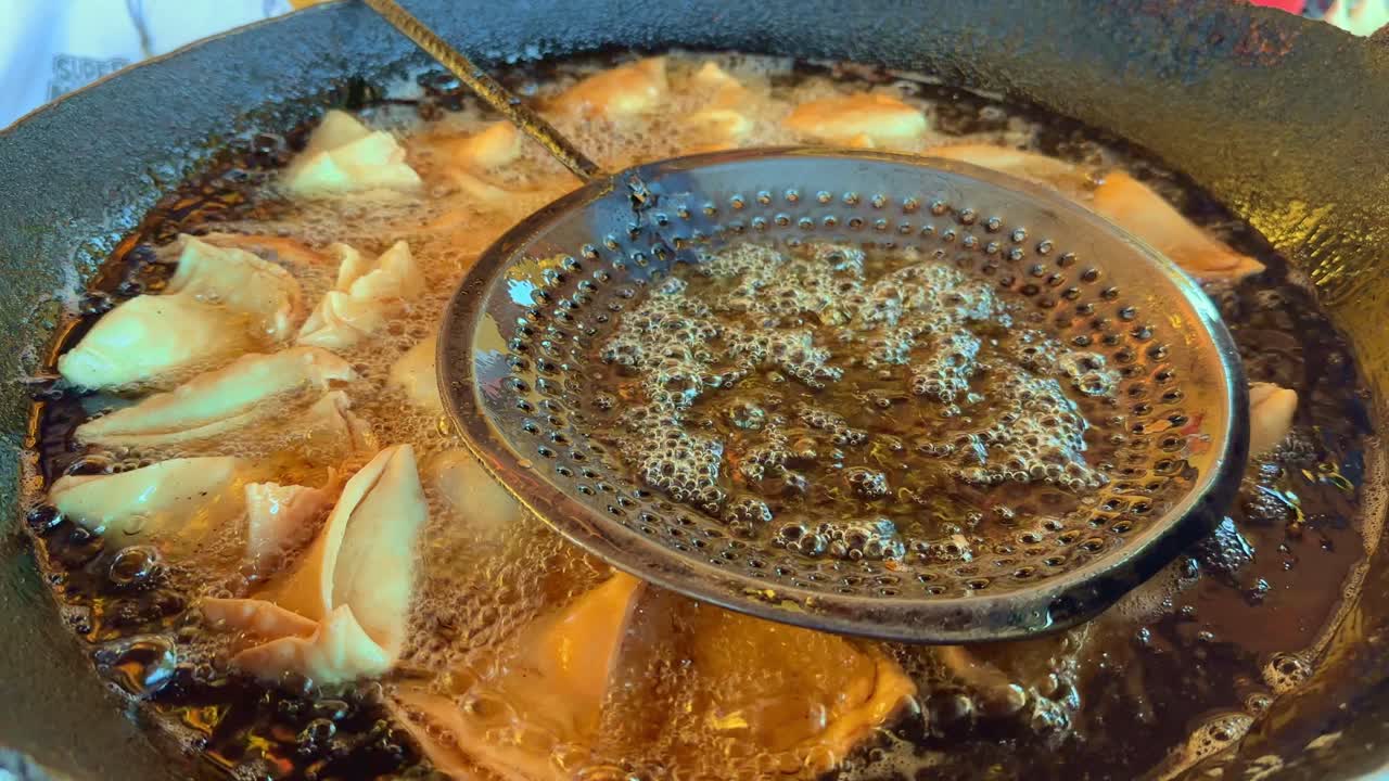 Samosa being fried in the hot oil at local food stall