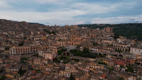 approaching duomo di san giorgio, modica. dramatic historic hillside old town. aerial drone perspective