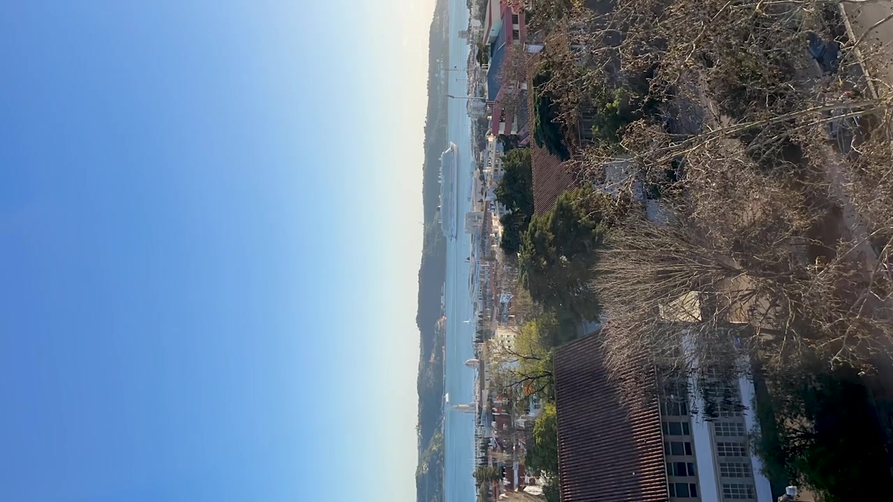 Un video timelapse verticale che riprende una nave da crociera mentre naviga con grazia il fiume Tago a Lisbona, Portogallo, con suggestivi paesaggi urbani e naturali che incorniciano il suo sereno movimento.