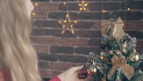 la mujer ajusta los arcos del árbol de navidad y el niño habla