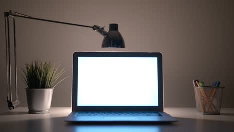 laptop with a white screen on the table at night