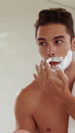 handsome man putting shaving foam on face