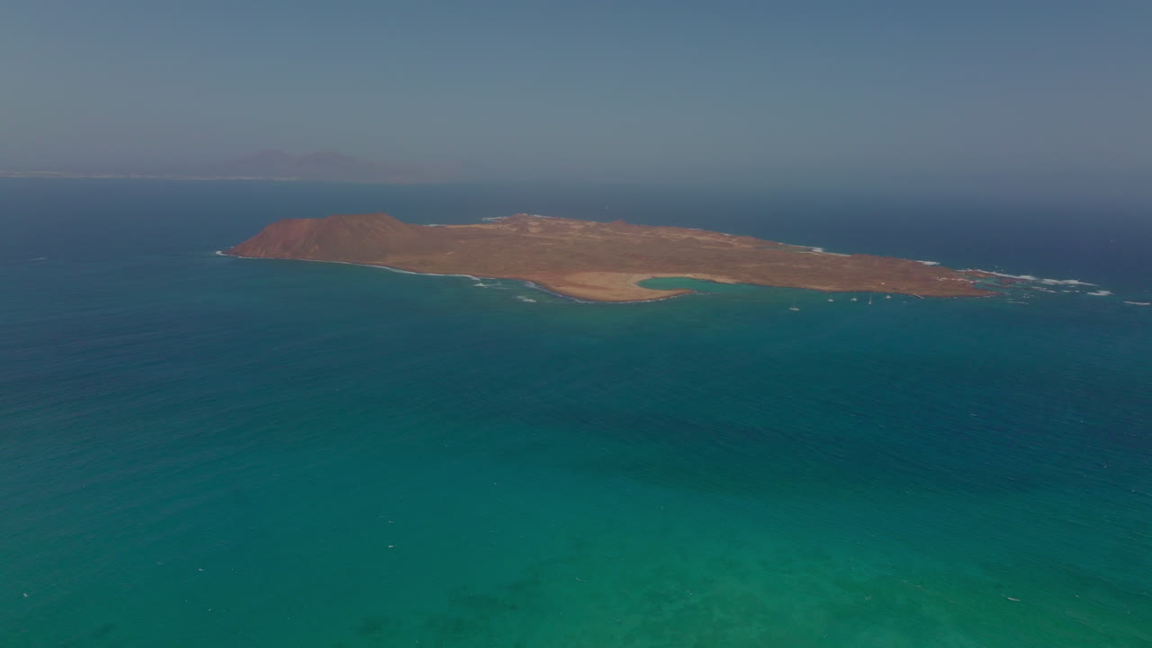 Breathtaking views of Fuerteventura with Lobos Island, Red Flag Beach, kite surfers, sunsets, volcanoes, sand dunes, and wingfoilers in the Canary Islands’ golden light.