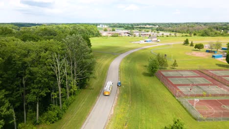 Overhead-drone-shot-of-a-firetruck-driving-through-the-countryside