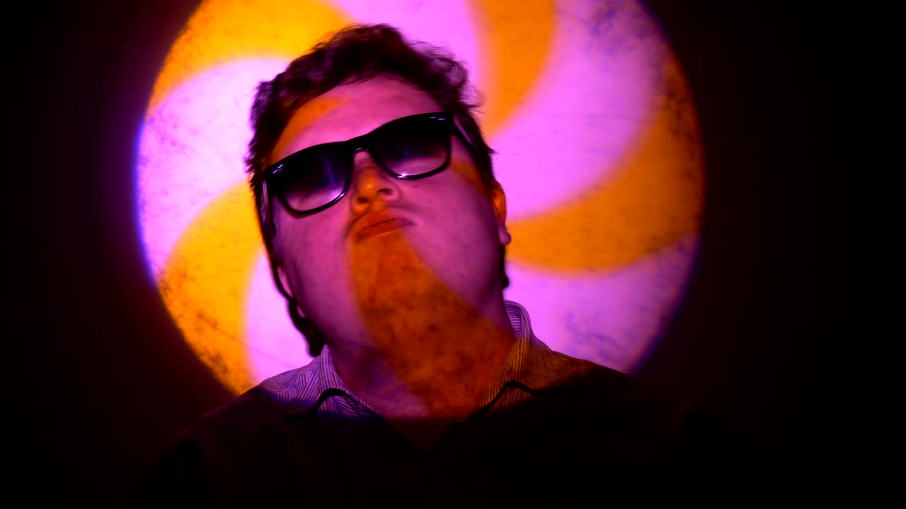 retrato de un hombre gordo en un haz de luz multicolor.