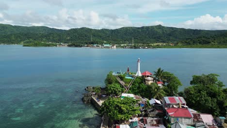 white lighthouse in exotic bay on the philippines, aerial orbit sunny day