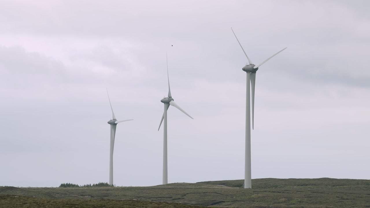 Static shot of three wind turbines turning in high winds on the Isle of Lewis.