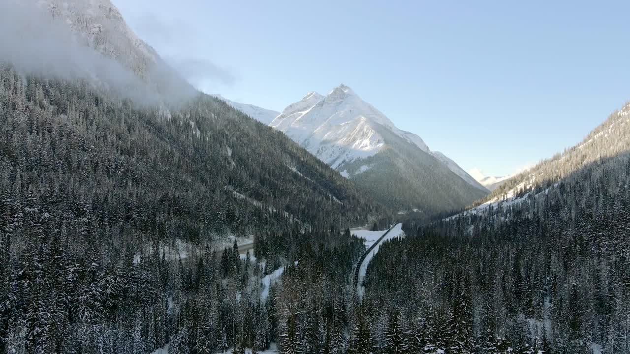 toma aérea de bosques nevados y majestuosas montañas en revelstoke, columbia británica: país de las maravillas invernal, impresionante paisaje invernal desde arriba