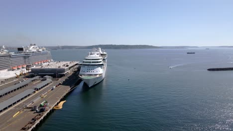 Aerial-view-of-docked-cruise-ships-at-a-Cruise-Ship-Port-Terminal-in-Seattle,-WA-USA-with-islands-in-the-background-on-a-sunny-day