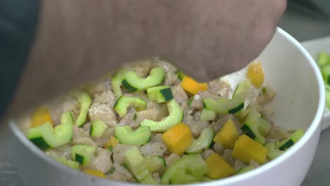 Up-close-shot-of-chef-hands-preparing-a-bowl-of-vegetables-and-fruits