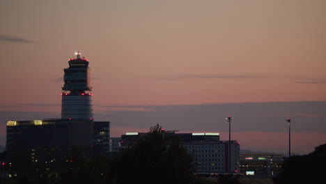 airplane landing at sunset over airport control tower