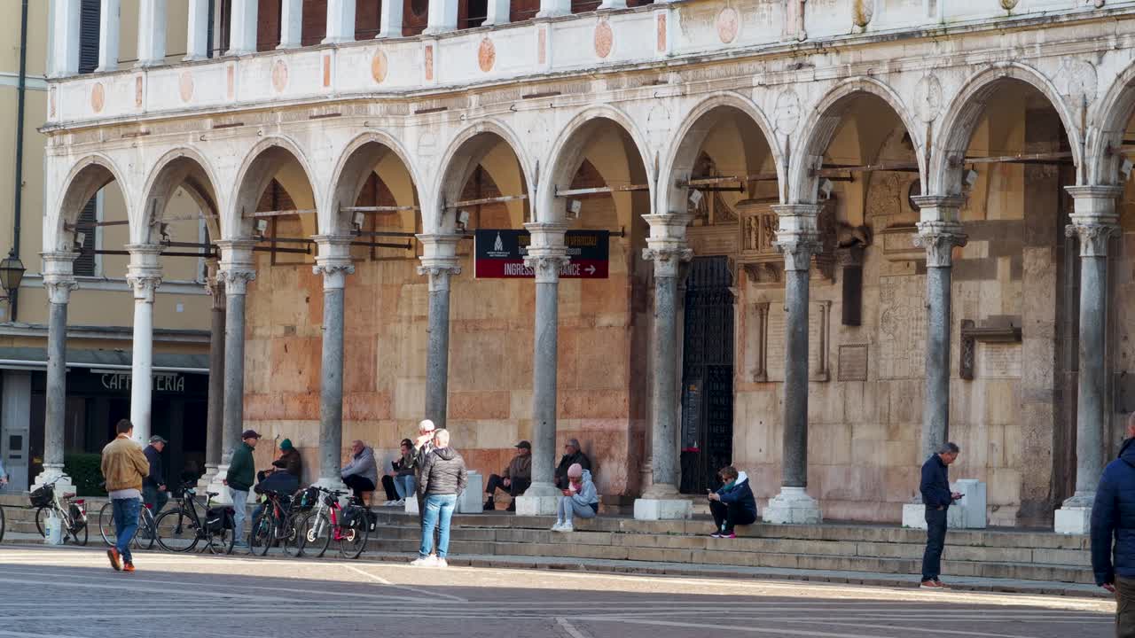Woman taking a selfie photo with smartphone with crowded historical landmark Duomo di Cremona, Italy in the background