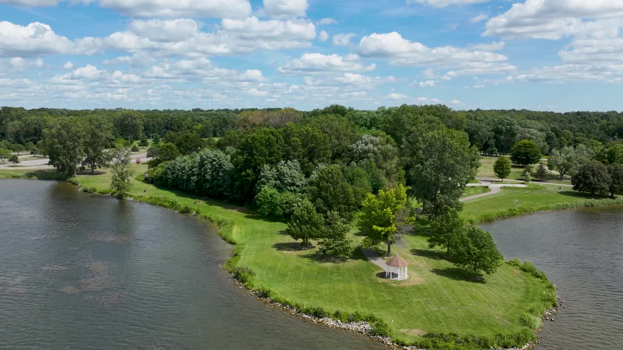 Pull back hyperlapse, time lapse drone shot at Stony Creek Metropark in Macomb County Michigan showing a gazebo and the lake at the park