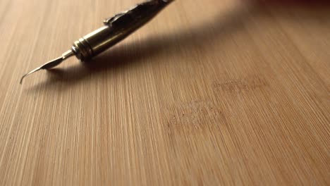 Feather-Pen-on-Wood-Background-Rotates