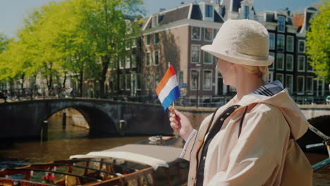 mujer ondeando la bandera holandesa en amsterdam