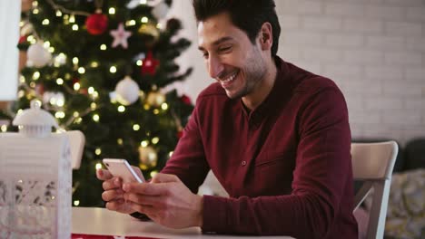 Man-with-mobile-phone-sending-the-best-wishes-for-Christmas