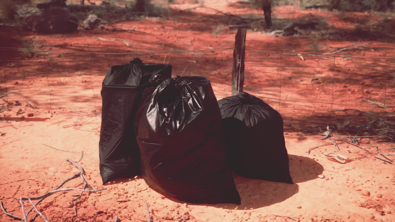 Tre sacchi neri della spazzatura in una località desertica remota