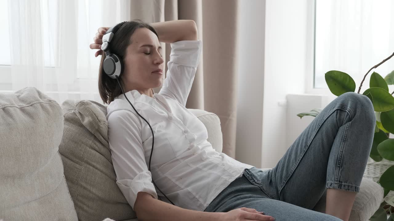 Relaxed woman listening to music on sofa