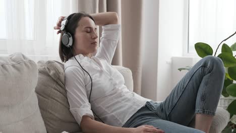 relaxed woman listening to music on sofa