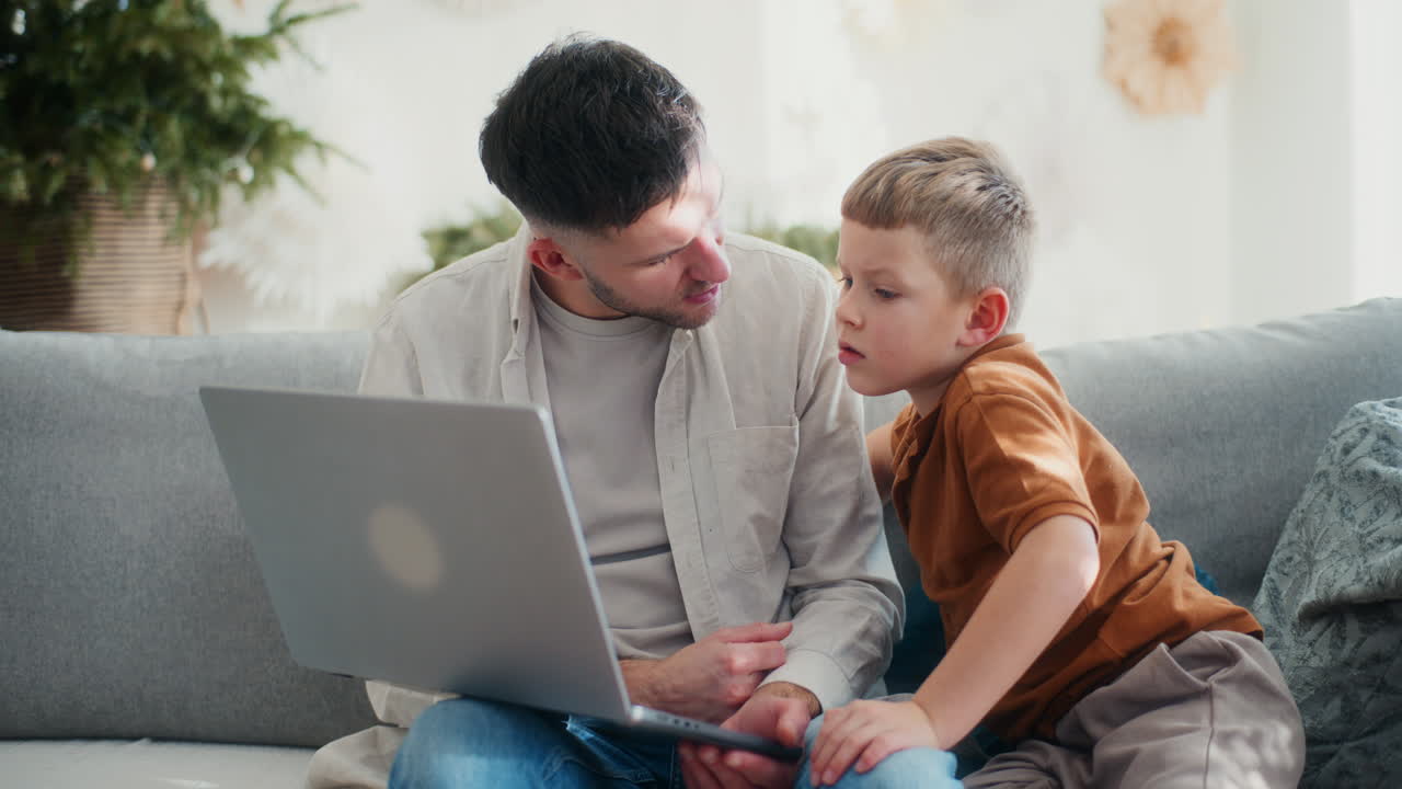 niño joven y papá comprando en línea en la computadora durante la navidad