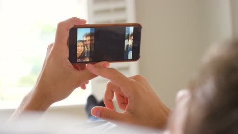 a man using a smartphone to look at photos