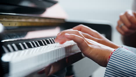 primer plano del alumno con el maestro tocando el piano en la lección de música