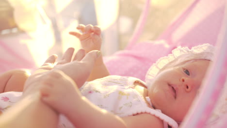 Mother-touching-hand-of-baby-daughter